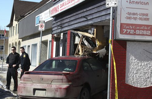 Winnipeg police stand by a crash scene in the 800 block of Sargent Avenue Sunday morning. The driver of the Honda Accord swerved inside Myrnas Café & Catering uninvited. March 8, 2015. Jessica Bothelo-Urbanski / Winnipeg Free Press