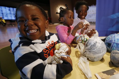 March 8, 2015 - 150308  -  Two year old Nathan Mushaganusa and his sisters Jessica and Jennifer make soccer balls from plastic bags at the Canadian Museum of Human Rights (CMHR) on International Women's Day Sunday, March 8, 2015. "This hands-on activity inspired by a story featured in the CMHR about young people in parts of Africa who can't afford sports equipment, so scour garbage dumps for plastic bags and string to transform Trash into soccer balls." - Maureen Fitzhenry, CMHR John Woods / Winnipeg Free Press
