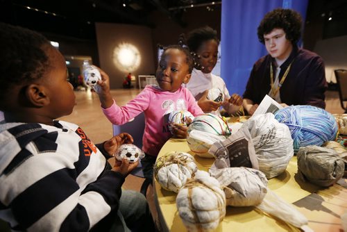 March 8, 2015 - 150308  -  Two year old Nathan Mushaganusa and his sisters Jessica and Jennifer make soccer balls from plastic bags with Braden McMillan at the Canadian Museum of Human Rights (CMHR) on International Women's Day Sunday, March 8, 2015. "This hands-on activity inspired by a story featured in the CMHR about young people in parts of Africa who can't afford sports equipment, so scour garbage dumps for plastic bags and string to transform Trash into soccer balls." - Maureen Fitzhenry, CMHR John Woods / Winnipeg Free Press