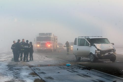Dangerous Work  Firefighters clean debris off the CentrePort Canada Way expressway after a three car mva in the fog Monday morning Mar 06, 2015   (JOE BRYKSA / WINNIPEG FREE PRESS)