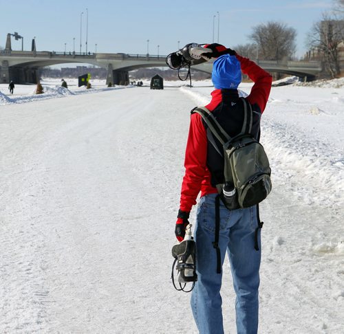 In red jacket and blue hat, Floyd Reichel checks out the closed Red River Trail. He said he wanted to go skating today but is late.  BORIS MINKEVICH/WINNIPEG FREE PRESS MARCH 9, 2015
