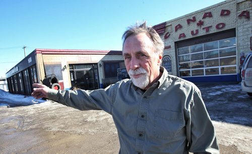 Dan Iwanchuk, third generation owner of Canada Auto, gestures how much of his parking lot at his auto mechanic shop at 1688 St.Matthews, and Route 90, will be taken from him. The City of Winnipeg has apparently sold off too much of the old football stadium land and now its trying to expropriate several properties around Polo Park to follow through on a plan to improve traffic.  150310 March 10, 2015 Mike Deal / Winnipeg Free Press