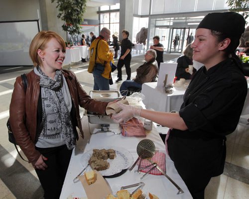 STANDUP - Child Nutrition Council of Manitoba Hosts Third Annual Stone Soup fundraiser- at Manitoba Hydro Place Lobby, 360 Portage Avenue. Left, U of W education student Jenna Baker gets served by R.B. Russell Vocational School student Rachel Gray. Soups created and served by some of Winnipegs best chefs. BORIS MINKEVICH/WINNIPEG FREE PRESS MARCH 11, 2015