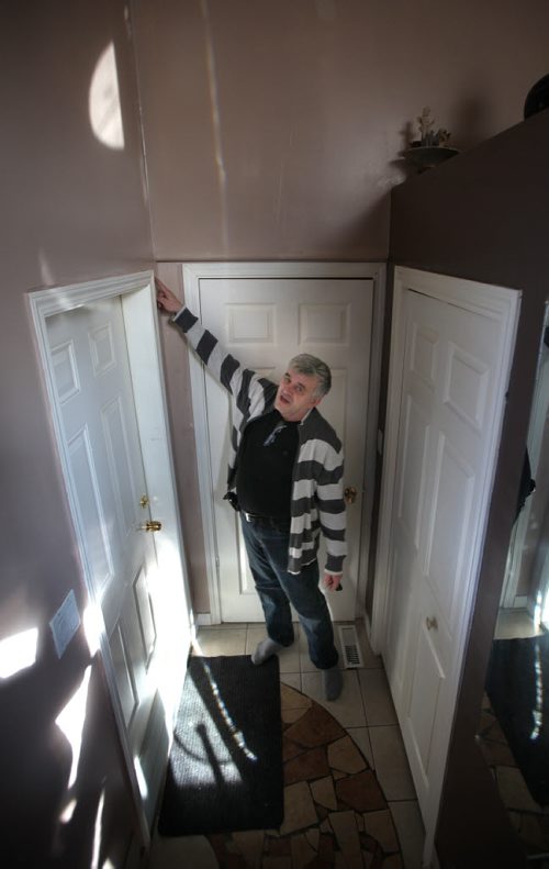 Zeljko Cupic points out cracked walls and sagging windows as his home rattles around him from work on the Plessis Underpass next to Paul Martin Drive. See Ashley Prest story. March 11, 2015 - (Phil Hossack / Winnipeg Free Press)