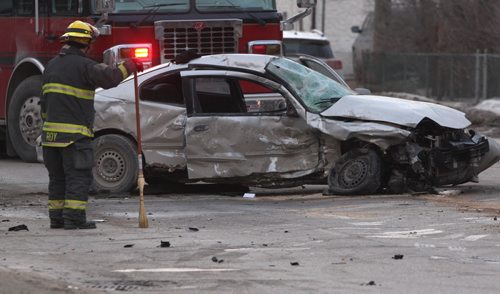 A fireman looks at the aftermath of a two car mva at Ellice Ave and Sherburn St Thursday morning-Police have blocked westbound traffic on Ellice as they investigate the crash that sent three to hospital-Breaking News- Mar 12, 2015   (JOE BRYKSA / WINNIPEG FREE PRESS)
