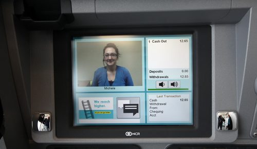 Teller Michelle beams back at Selkirk customers from her Gimli  Noventis Credit Union workstation. The province's first ITM. The "I" stands for "interactive."  When you go to the ATM, you press a button and are immediately hooked up via video with a teller at their headquarters in Gimli. From there, it's just like being in a branch. For example, you can withdraw any amount of money, not just in increments of $20 or $50. See Geoff Kirbyson's story. (March 12, 2015 - Phil Hossack / Winnipeg Free Press)