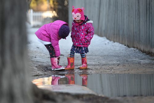 Three-year-old Hannah Braico and her sister Maddie, enjoy playing in the muck and puddles in the backlane behind their home in River Heights Friday afternoon as their father looks on.  (Dad not in photo).  March 13, 2015 Ruth Bonneville / Winnipeg Free Press.