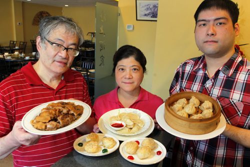 RESTAURANT REVIEW - Hai Shang at 2991 Pembina Highway. Left to right. Chef Bai Rong Shen (holding Deep Fried Duck), Yan Yan Lu (holding bean pastries(front) and Fish Dumplings(back)), and Jack Shen (holding Soup Dumplings). BORIS MINKEVICH/WINNIPEG FREE PRESS MARCH 16, 2015