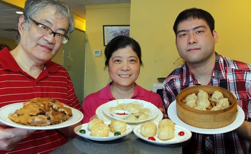 RESTAURANT REVIEW - Hai Shang at 2991 Pembina Highway. Left to right. Chef Bai Rong Shen (holding Deep Fried Duck), Yan Yan Lu (holding bean pastries(front) and Fish Dumplings(back)), and Jack Shen (holding Soup Dumplings). BORIS MINKEVICH/WINNIPEG FREE PRESS MARCH 16, 2015