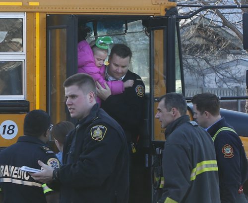 A paramedic carries one of the passengers out of a school bus that collided with a car Tuesday morning.Adam Wazny story.Wayne Glowacki/Winnipeg Free Press March 17 2015