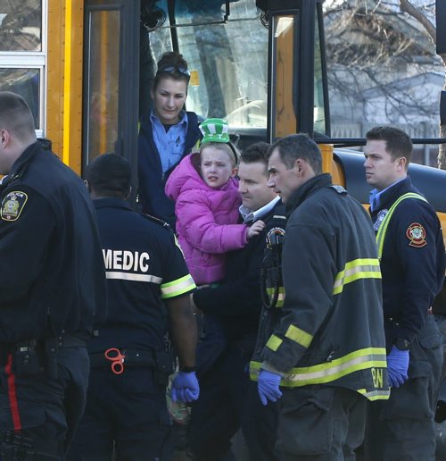 A paramedic carries one of the passengers out of a school bus that collided with a car Tuesday morning.Adam Wazny story.Wayne Glowacki/Winnipeg Free Press March 17 2015