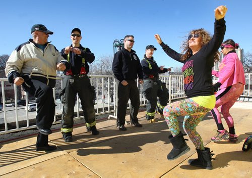 Zumba on the Roof- Firefighters L to R  Alan Bartley-(ret), Mike Lisowic, Chad Swayze, and Darby Hopkins join Zumba instructors Lesly Katz, front, and Sharon Delbridge in dance on the rooftop of Fire Station #4 on Osbourne during day one of the 6th Annual Winnipeg Fire Fighter Rooftop Campout for Muscular Dystrophy Canada. The campaign is 72 hours of  fundraising in support of local families affected by neuromuscular disorders.-Standup Photo- Mar 17, 2015   (JOE BRYKSA / WINNIPEG FREE PRESS)