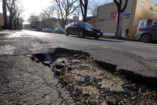 LOCAL - Pot holes in the 300 block of Stradbrook Ave. potholes. BORIS MINKEVICH/WINNIPEG FREE PRESS MARCH 17, 2015