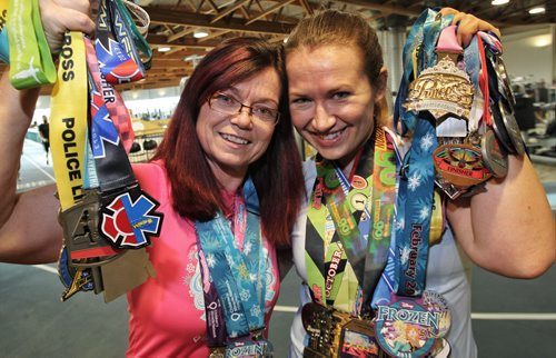 Annette Pratt (left) and Lisa Marquardson (right) have a lot of hardware from all the marathons they have taken part in. They go on "run-cations" to keep themselves motivated to stay in shape.  150318 March 18, 2015 Mike Deal / Winnipeg Free Press