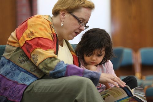 Four-year-old Aibhlinn listens intently to lawyer Karen Burwash at the 5th annual West Broadway Lawyers for Literacy Read-A-Thon Saturday morning.   Standup photo  March 21, 2015 Ruth Bonneville / Winnipeg Free Press