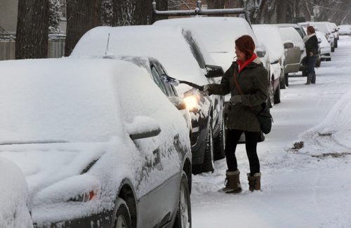 Renee Fulkerson cleans snow from her car on Home St Monday morning in Winnipeg-Standup Photo- Mar 12, 2015   (JOE BRYKSA / WINNIPEG FREE PRESS)