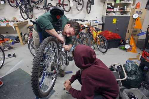 Marymound students repair bikes to help others in need for Helping International Hope Canada in fight against Ebola virus  Instructor Travis Liewicki works with bike for Bikes for Humanity-Winnipeg Chapter operated out of Marymound Tuesday. They are sending 20 recycled bikes through International Hope Canada (IHC) to Sierra Leone on April 11, along with other medical supplies to aid doctors in caring for patients affected by the Ebola virus. The bicycles are essential transportation for the doctors to reach their patients in numerous villages. Standup Photo-( Eds note the child is in care and could not be identified or photographed to be recognizable)- Mar 24, 2015   (JOE BRYKSA / WINNIPEG FREE PRESS)