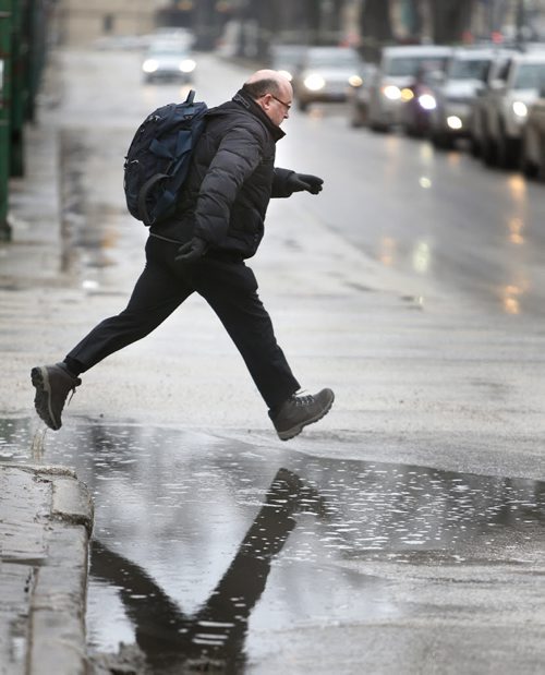 An afternoon rain shower Tuesday had pedestrians puddle jumping on Broadway. weather story Wayne Glowacki/Winnipeg Free Press March 24 2015