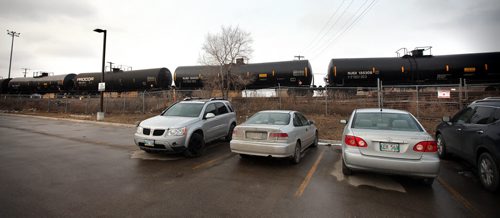 City center workers park cars adjacent to the rail yards and a train made up of oil tanker cars flowing through the city center. See story. March 27, 2015 - (Phil Hossack / Winnipeg Free Press)