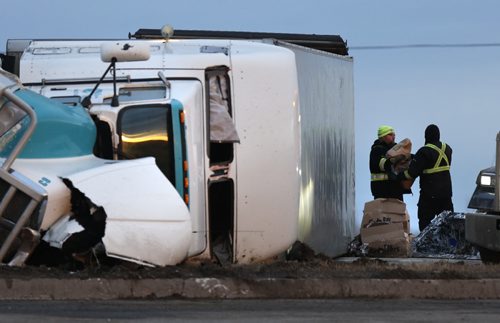 Produce is unloaded from an over turned semi-trailer on the Perimeter Hwy. near McGillvray Blvd. Monday morning after the vehicle rolled over at aprox. 1:30A.M. The 45-year-old male driver was not injured in the collision.Wayne Glowacki/Winnipeg Free Press March 30 2015 ¤