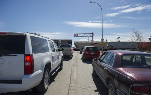 150331 Winnipeg - DAVID LIPNOWSKI / WINNIPEG FREE PRESS  Traffic waits for a train to cross the Waverley at Taylor train tracks Tuesday March 31, 2015.