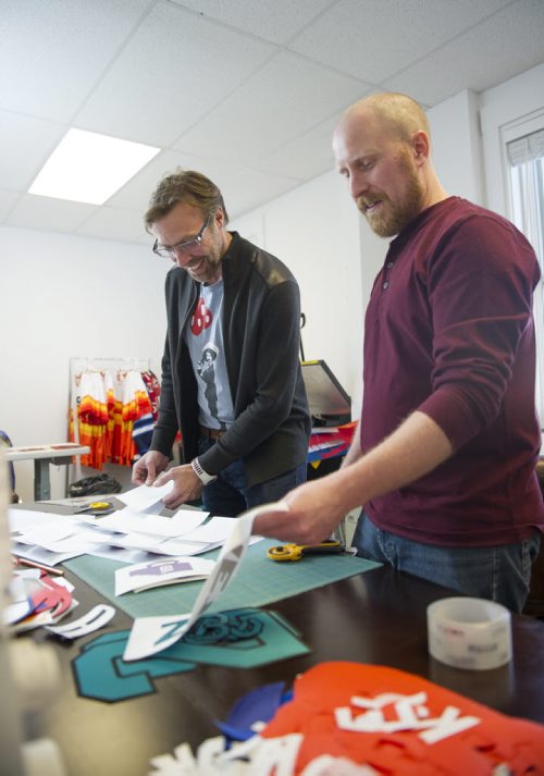 150331 Winnipeg - DAVID LIPNOWSKI / WINNIPEG FREE PRESS  Jason Olson (left) and Chris (Keener) Dougherty works on jersey prep Tuesday March 31, 2015. Chris (Keener) Dougherty and Jason Olson started their company, Keener Jerseys, late last year but Keener has been one of the top jersey customizers in the world for almost 20 years.  Dave Sanderson story