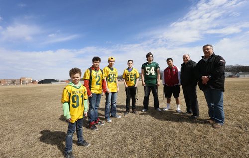 Saturday Special. Football players from left, brothers Owen, Noah and Matthew Sampson, Kaiden Bannon, with the  Nomads, Jayson Saunders with the Tec Voc High School Hornets, Kevin Ebron, with the Daniel McIntyre Maroons, beside Frank Zappia Chair, North West Football Committee and Rick Henkewich, commissioner of the Winnipeg High School Football League on the field  south of Tec Voc H.S.school where they hope to transform it into a football stadium.  Nick Martin story Wayne Glowacki/Winnipeg Free Press April 1 2015