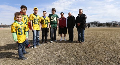 Saturday Special. Football players from left, brothers Owen, Noah and Matthew Sampson, Kaiden Bannon, with the  Nomads, Jayson Saunders with the Tec Voc High School Hornets, Kevin Ebron, with the Daniel McIntyre Maroons, beside  Frank Zappia Chair, North West Football Committee and Rick Henkewich, commissioner of the Winnipeg High School Football League on the field south of Tec Voc H.S.school where they hope to transform it into a football stadium.  Nick Martin story Wayne Glowacki/Winnipeg Free Press April 1 2015