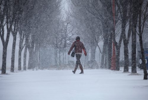 A person quickly makes their way toward the entrance to the Canadian Museum for Human Rights as a flash snowstorm hits Winnipeg Thursday.   Weather Standup  April 2, 2015 Ruth Bonneville / Winnipeg Free Press.