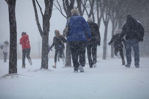 People brace themselves front he wind and snow near the entrance to the Canadian Museum for Human Rights as a flash snowstorm hits Winnipeg Thursday.   Weather Standup  April 2, 2015 Ruth Bonneville / Winnipeg Free Press.