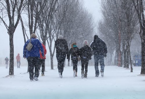 People brace themselves front he wind and snow near the entrance to the Canadian Museum for Human Rights as a flash snowstorm hits Winnipeg Thursday.   Weather Standup  April 2, 2015 Ruth Bonneville / Winnipeg Free Press.