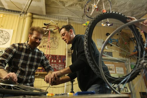 Bike mechanic instructor Glenn Macauley (in black) teaches students how to fix a flat tire at the first bike workshop of the year at The Bike Dump, a Community Bike Shop in downtown Winnipeg just behind the Red Road Lodge.  Every Saturday (1 - 3) in April they are offering a free beginner bicycle repair workshop series from tune ups to gears. Registration is not necessary.  Our goal has always been to make bicycle repair skills available to everyone, regardless of gender, age, or income, says Glenn Macauley, one of the founders and volunteers of the Bike Dump.   Standup photo Ruth Bonneville / Winnipeg Free Press April 04,2015