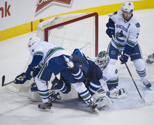150404 Winnipeg - DAVID LIPNOWSKI / WINNIPEG FREE PRESS  Winnipeg Jets Mathieu Perreault (#85) is upside down in the Vancouver crease during first period action against the Vancouver Canucks Saturday April 4, 2015 at the MTS Centre.