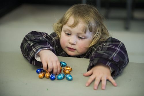 150405 Winnipeg - DAVID LIPNOWSKI / WINNIPEG FREE PRESS  Ella Symaka (age 2) collects her chocolate eggs Sunday April 5, 2015 after taking part in the Royal Aviation Museum of Western Canada's Easter Egg Hunt. About 500 people came out on Sunday to participate.