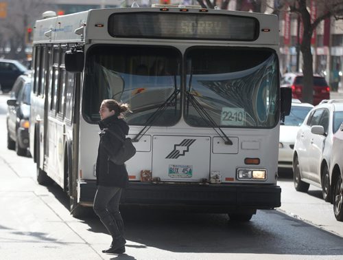 Stacey Manzuik  walks across Portage ave  at Carlton street past a transit bus Wednesday. She was struck by a transit bus at this interesction on Nov. 29, 2011 and survived (bus ran a red light). See Kevin Rollason follow to yesterday's pedestrian/Bus fatality. April 8, 2015 - (Phil Hossack / Winnipeg Free Press)  ¤