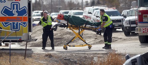 Paramedics care for an occupant of a vehicle that rolled into a ditch after colliding with a "First Canada"  bus on Main Street  north of River Grove Thursday afternoon. April 9, 2015 - (Phil Hossack / Winnipeg Free Press)