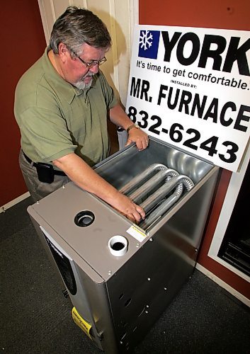BORIS MINKEVICH / WINNIPEG FREE PRESS 071018 Bryan Klinkhammer is the general Manager of New Homes Furnaseman poses for a photo next to a high efficient furnace in his showroom.