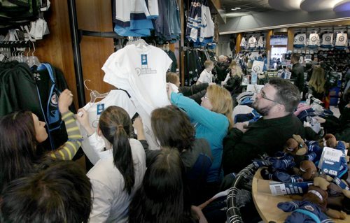 White Out Frenzy- L to R -Jets fans scramble to grab white Jets jerseys and t-shirts  at the MTS Centre Friday morning - The Jets secured a Stanley Cup playoff spot yesterday and over 300 fans lined up for the opening of the store -See Geoff Kirybson story- Apr 10, 2015   (JOE BRYKSA / WINNIPEG FREE PRESS)