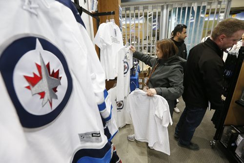 Dez Pope looks for her new white Winnipeg Jets apparel in the Jets Gear store in Winnipeg, Friday, April 10, 2015. Thousands of Winnipeg Jets fans lined up to get their hands on some white Jets merchandise after a "whiteout" was announced for their  team's home NHL playoff games.   THE CANADIAN PRESS/John Woods