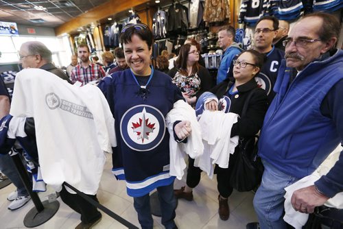 Nicky Chabluk was excited to get her hands on her new white Winnipeg Jets apparel at the Jets Gear store in Winnipeg, Friday, April 10, 2015. Thousands of Winnipeg Jets fans lined up to get their hands on some white Jets merchandise after a "whiteout" was announced for their  team's home NHL playoff games.   THE CANADIAN PRESS/John Woods