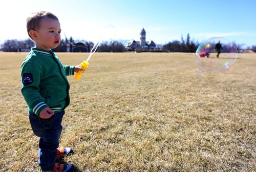 Lucas Dempsey, 23mo, appears to catch his father, Aaron, while playing with bubbles along with his mother, Marie, in Assiniboine Park, Saturday, April 11, 2015. (TREVOR HAGAN/WINNIPEG FREE PRESS)