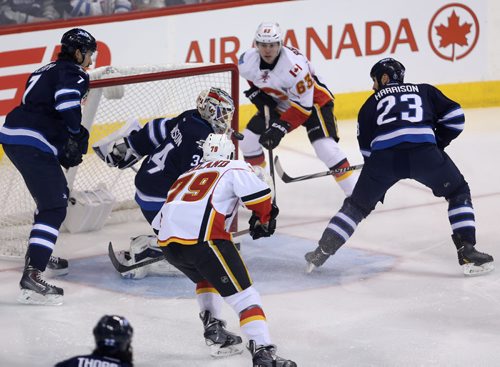 Calgary Flames' Sam Bennett (63) at the side of the net and Michael Ferland (79) right before Ferland opened the scoring on Winnipeg Jets' goaltender Michael Hutchinson (34) in the first minute of NHL hockey action, Saturday, April 11, 2015. (TREVOR HAGAN/WINNIPEG FREE PRESS)
