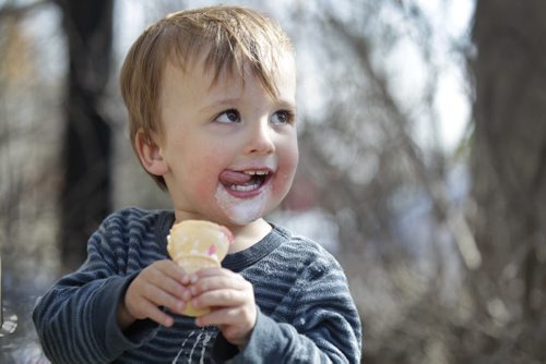 Two-year-old Simon Geisel enjoys his ice cream cone sitting outside with his family  in the warm sunshine at Sargent Sundae Saturday afternoon. Standup   Ruth Bonneville / Winnipeg Free Press March 26, 2015