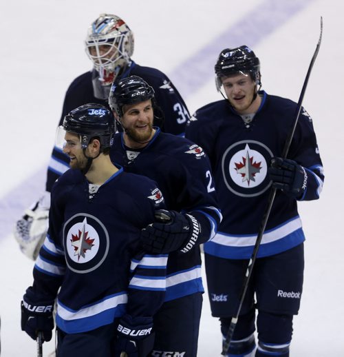 Winnipeg Jets' TJ Galiardi (21), Adam Pardy (2), goaltender Michael Hutchinson (34) and Andrew Copp (51) all smiling after the team's victory against the Calgary Flames' during NHL hockey action, Saturday, April 11, 2015. (TREVOR HAGAN/WINNIPEG FREE PRESS)