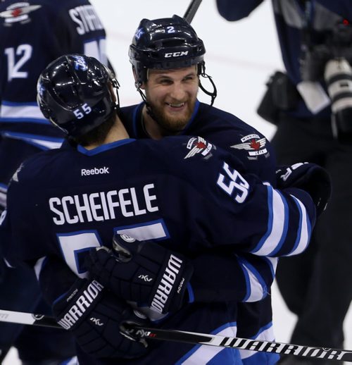 Winnipeg Jets' Mark Scheifele (55) and Adam Pardy (2) celebrate after the team's victory against the Calgary Flames' during NHL hockey action, Saturday, April 11, 2015. (TREVOR HAGAN/WINNIPEG FREE PRESS)