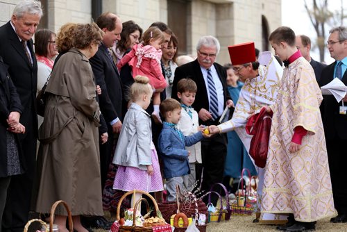 Father Gene Maximiuk gives an Easter Egg to a young boy as His Eminence Metropolitan Yurij, Archbishop of Winnipeg and the Central Eparchy, not shown, leads Pascha service at Holy Trinity Ukrainian Orthodox Cathedral, Sunday, April 12, 2015. (TREVOR HAGAN/WINNIPEG FREE PRESS)