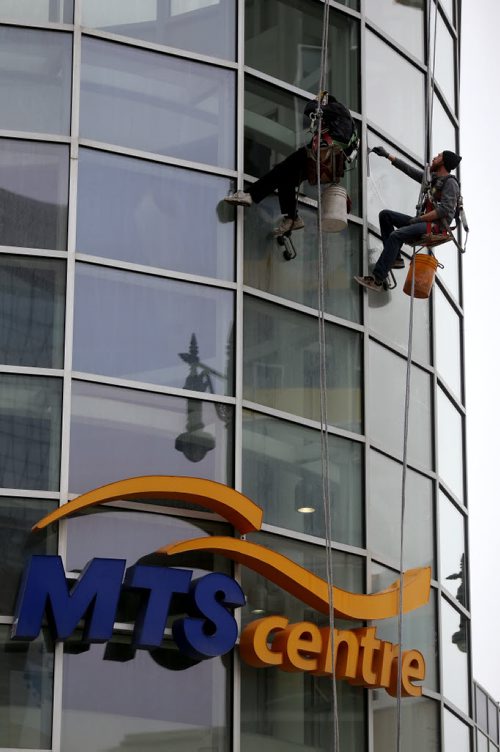 Window washers preparing MTS Centre after the Winnipe Jets' regular season completed Saturday afternoon against the Calgary Flames, Sunday, April 12, 2015. The Jets' first playoff game goes April 16 and the first home game will be next Monday. (TREVOR HAGAN/WINNIPEG FREE PRESS)