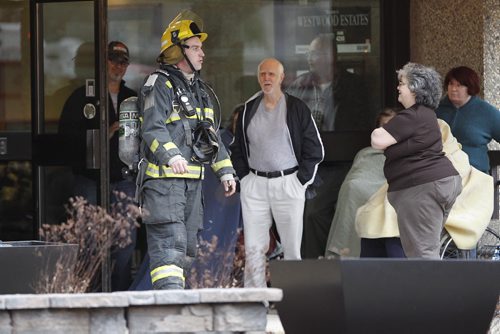 April 12, 2015 - 150412  -  A firefighter talks to residents as emergency personnel attend a fire on an apartment balcony at 429 Westwood Sunday, April 12, 2015. John Woods / Winnipeg Free Press