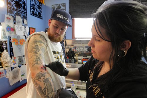 JETS TATTOO - (right) South of Heaven Tattoo artist Karen Melia puts a Winnipeg Jets tattoo on Lawrence Lavallee.  BORIS MINKEVICH/WINNIPEG FREE PRESS APRIL 15, 2015