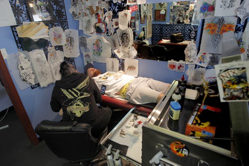 JETS TATTOO - (left) South of Heaven Tattoo artist Karen Melia puts a Winnipeg Jets tattoo on Lawrence Lavallee.  BORIS MINKEVICH/WINNIPEG FREE PRESS APRIL 15, 2015